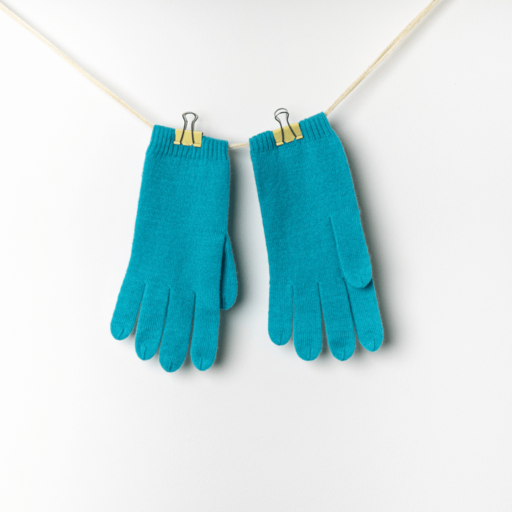 Baltic 100% Cashmere Gloves hanging on a twine string against a white wall#color_baltic