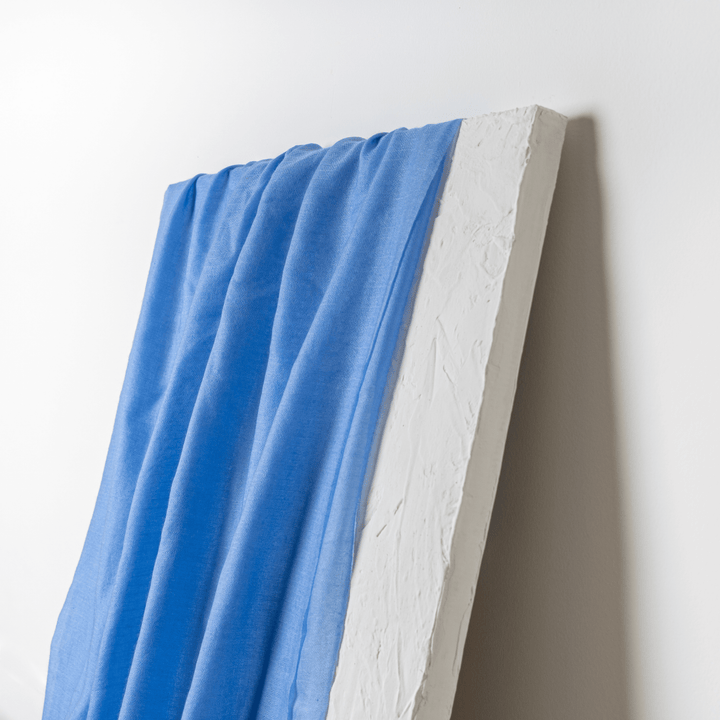 Bel Air Blue 100% Cashmere Ring Scarf draped like a curtain over a white artistically-placed sheet of drywall#color_bel-air-blue