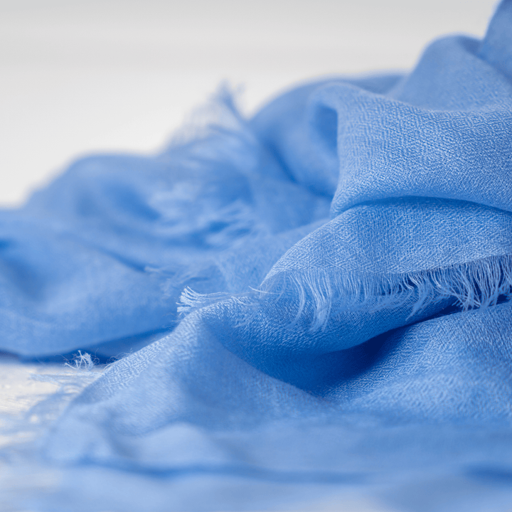 Close-up of fluffy Blue Tint 100% Cashmere Ring Scarf displaying raw edges#color_blue-tint