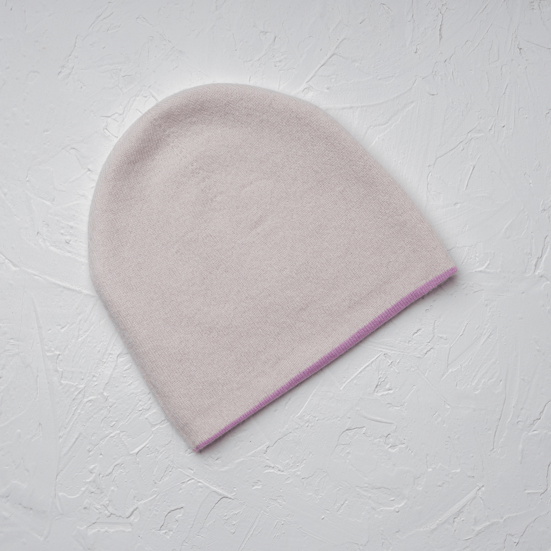 White Side of Reversible 100% Cashmere Beanie in Tender Touch(Pink) and Blanc de Blanc(White) lad flat against white drywall#color_tender-touch-and-blanc-de-blanc