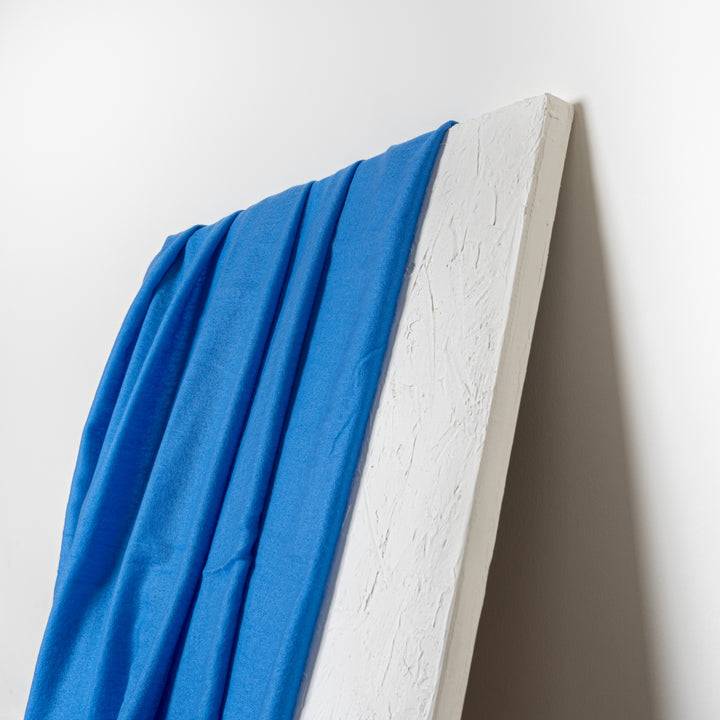 Blue 100% Cashmere Felted Shawl draped like a curtain over a white artistically-placed sheet of drywall#color_blue