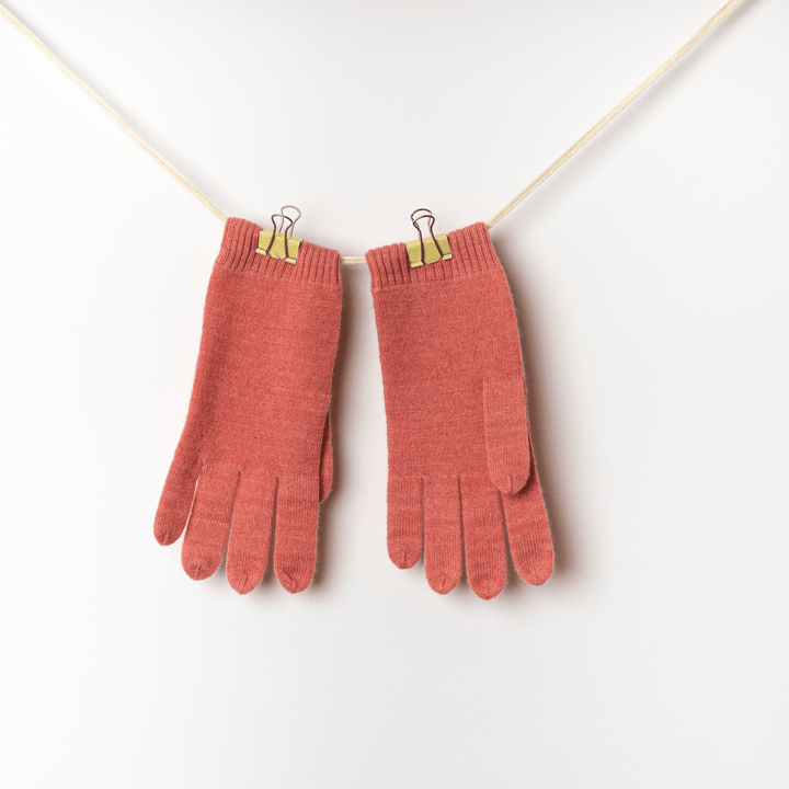 Lantana 100% Cashmere Gloves hanging clipped on a twine string against a white wall#color_lantana
