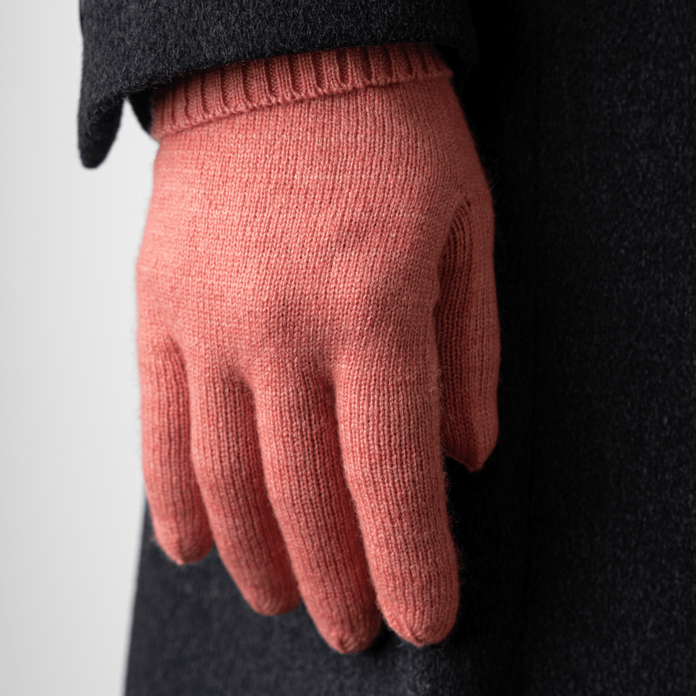 Lantana 100% Cashmere Gloves worn on the right hand held down by the side of a body wearing a dark grey trench coat#color_lantana